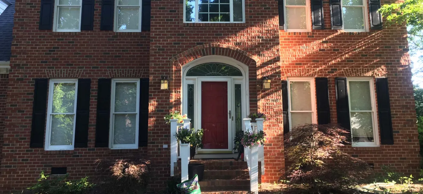 Exterior painting — brick home with freshly painted trim and red front door